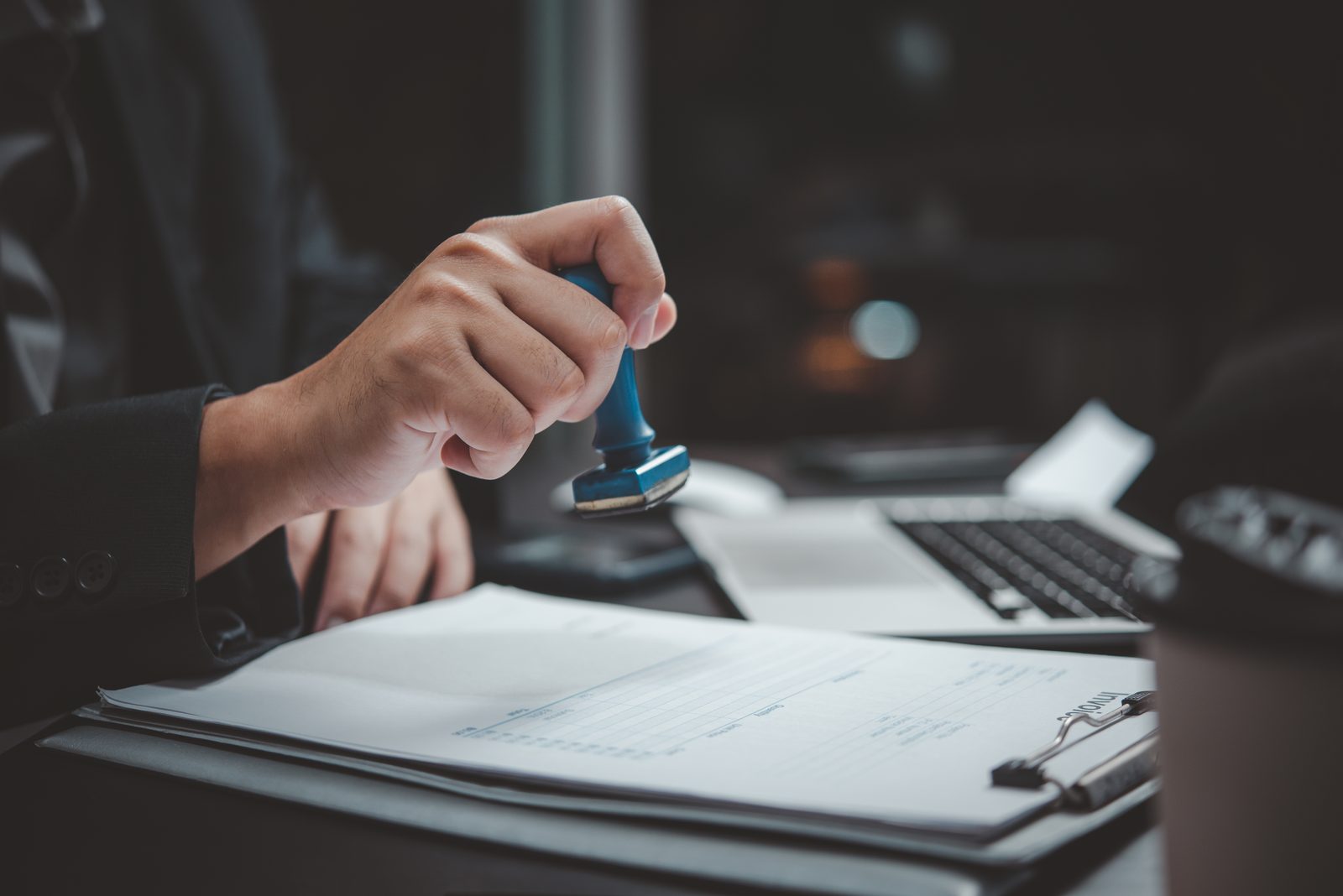 Reviewer stamping a compliance document